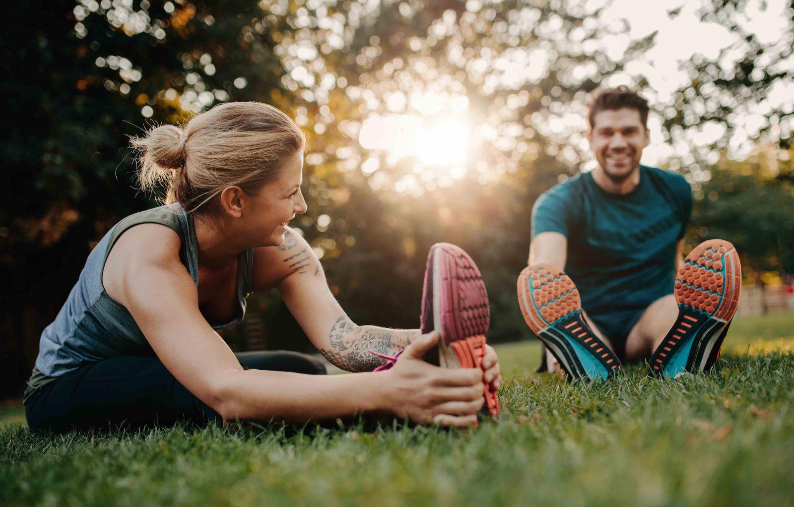 happy fitness couple stretching in park
